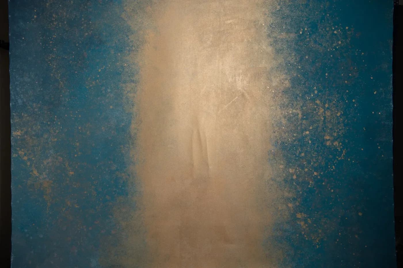 Teal hand-painted canvas backdrop with a warm gold centre glow and scattered gold speckling