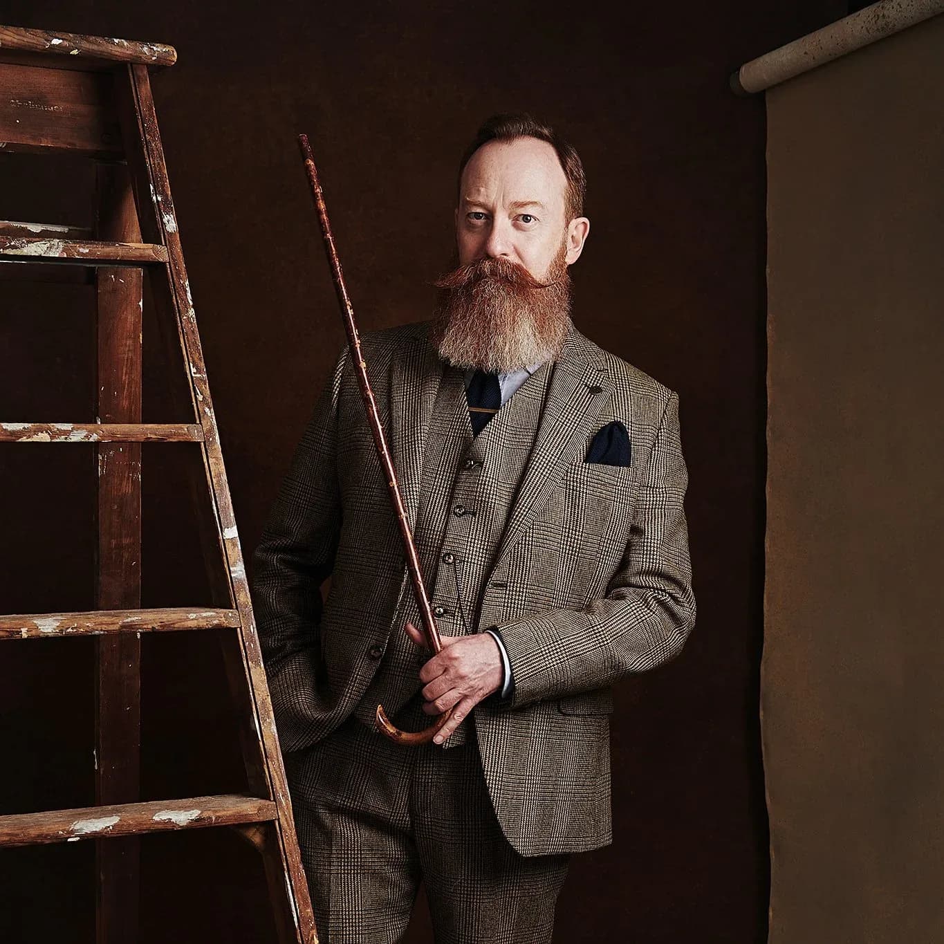 Studio portrait lit against a hand-painted backdrop